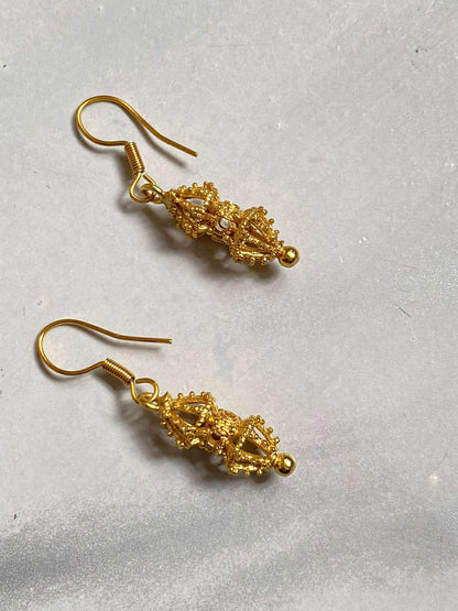 Pair of gold earrings on a light gray background