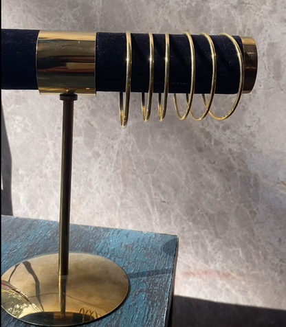 Crafted from high quality Panchadhatu, this minimalist bracelet offers a smooth gold finish that reflects quiet elegance. Its refined silhouette brings a polished touch to any outfit, whether you are heading out for the day or elevating your everyday style.
The fixed size design gives the bracelet a clean, uninterrupted profile that feels intentional and timeless. A classic piece for those who appreciate tradition, craftsmanship, and understated sophistication.