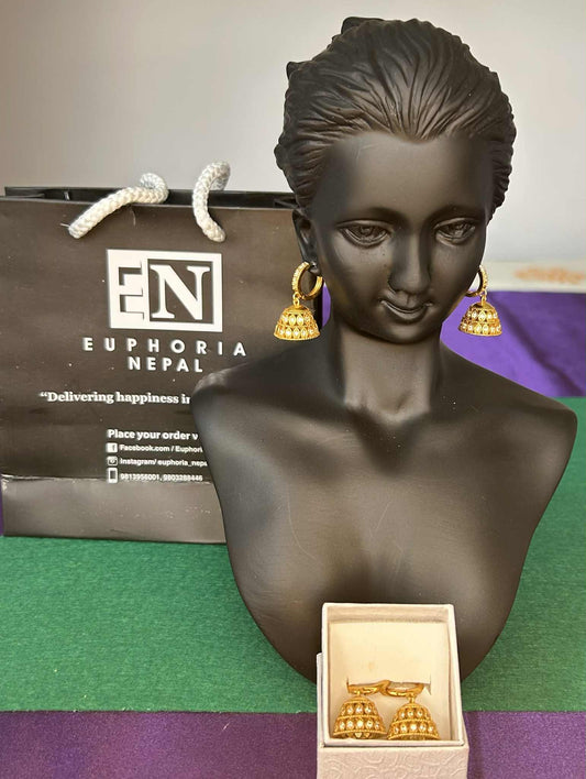 Gold earrings on a black bust with Euphoria Nepal packaging in the background